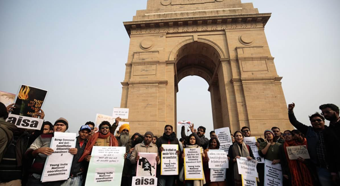 Peaceful demonstrators in India holding placards during a public gathering demanding democratic accountability.